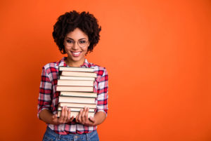 Woman holding many books.
